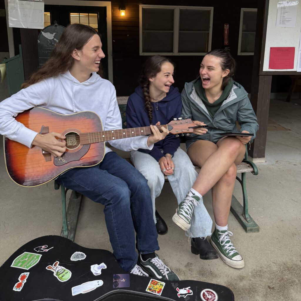 Dates and Rates 2 Laughing w guitar scaled e1769733129412, Camp Encore Coda